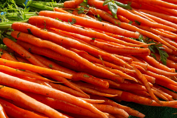 A view of a pile of carrots, on display at a local farmers market.