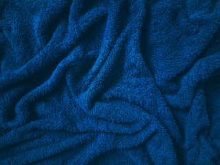 Abstract texture of wrinkled dark blue fluffy towel