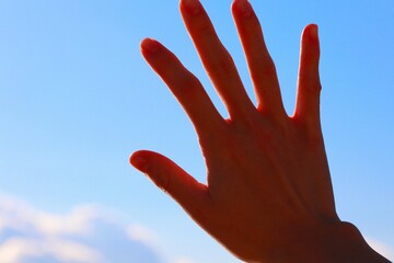 空に手をかざす女性の手