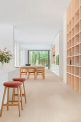 Fototapeta premium Modern interior design featuring a minimalist dining space with natural light and greenery