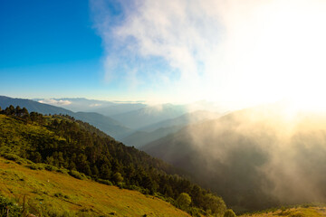 Nature background photo. Forest covered mountain range with haze at sunset
