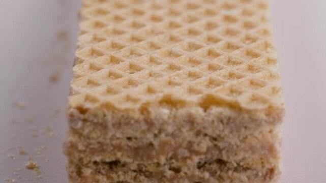 Detail view of one crispy wafer stick filled cream. Slider shot. Snacks, desserts, bakery, confectionery treats concepts. 4k