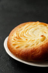 Deliciously baked spiral pastry garnished with a golden crust on a white plate