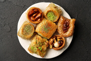 Assorted sweet pastries served on a white plate with nuts and syrup, showcasing traditional dessert presentation