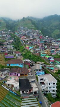 Colorful houses dot the slopes of Mount Sumbing, creating a vibrant and picturesque scene. Known as Nepal van Java, the hillside village radiates charm against a majestic mountain backdrop.