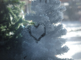 Hand draws love heart on cold fogged window background, closeup image