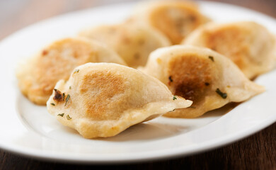Dumplings with potato and cottage cheese stuffing (pierogi). Wooden background. Close up.
