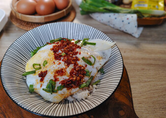 A close-up of a delicious and vibrant rice bowl topped with perfectly fried eggs, a generous drizzle of chili oil, and fresh scallions. 