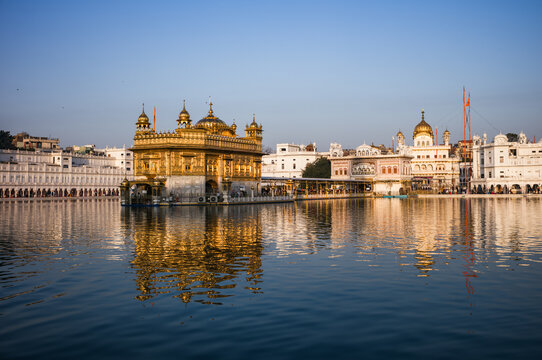 Sunrise at the golden sikh temple reflected into water, Amritsar, Punjab, India