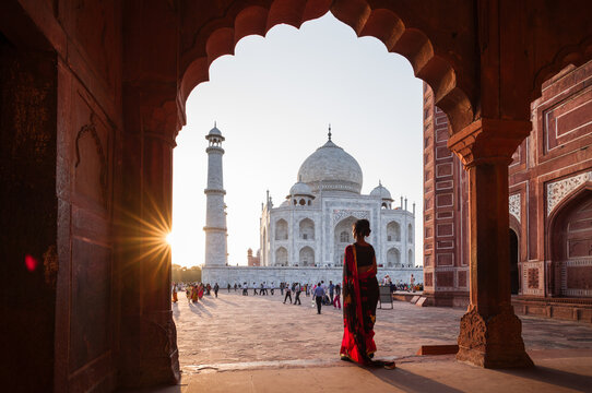 Indian woman looking at the Taj Mahal mausoleum at sunset, Uttar Pradesh, India