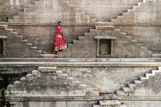 Indian woman wearing traditional saree on a staircase inside a stepwell, Jodhpur, Rajasthan, India
