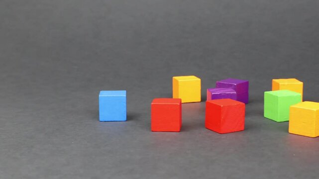 Colorful wooden cubes scattered on the matte black background.