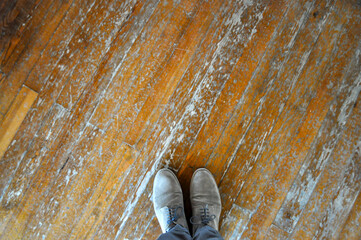 Top view of a man's brown shoes. Male feet on wooden floor. Lace-up suede shoes. Copy space, blank, empty. Above. Horizontal photo.