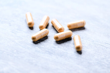 Korean Ginseng capsules. Concept for a healthy dietary supplementation. Wooden background. Soft focus. Close up.