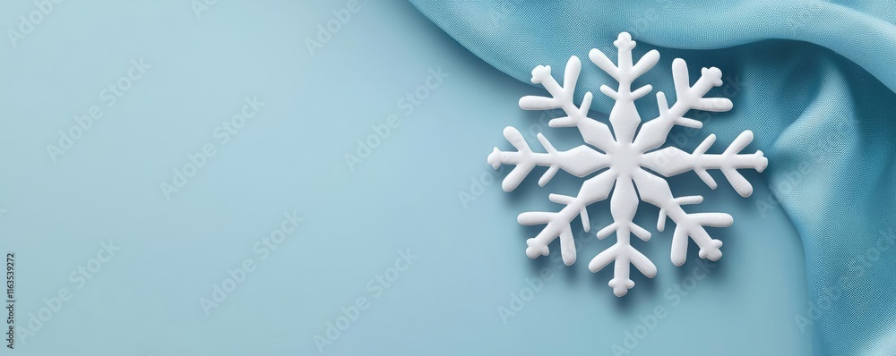 Poster Snowflake abstract background idea. A delicate snowflake resting on soft blue fabric, capturing winter's beauty and serenity.