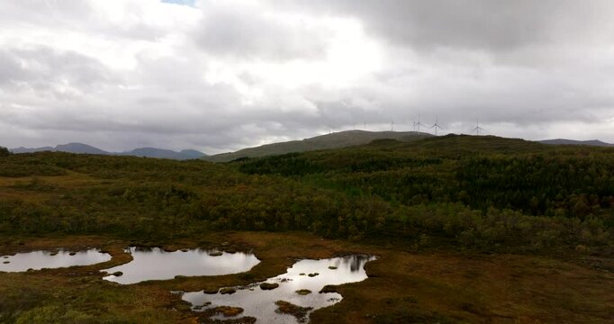 Small Ponds Near Forest Mountains With Wind Turbines Backdrop Near Sortland, Norway. Aerial Drone Shot