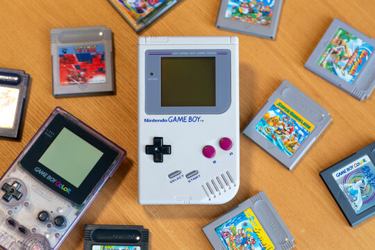 Fukuoka, Japan - december 30, 2024 : nintendo game boy and game boy color with various hit game cartridges isolated on wooden background
