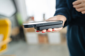 unknown woman hands holding phone and power bank charge