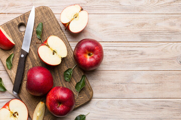 Fresh red apples with green leaves on table. cutting board with knife. Top view