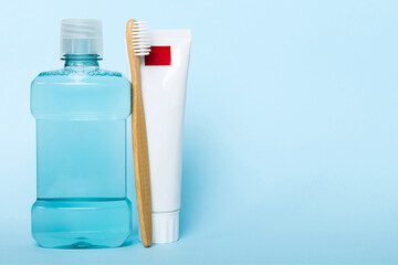 Mouthwash and other oral hygiene products on colored table top view with copy space. Flat lay. Dental hygiene. Oral care products and space for text on light background. concept
