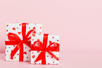 gift box with red bow and red heart on colored background. Perspective view. Flat lay