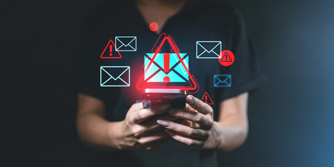 Warning email spam alert on device screen held by user.