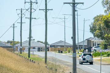A car driving towards a residential street lined with modern single-story houses in a new...