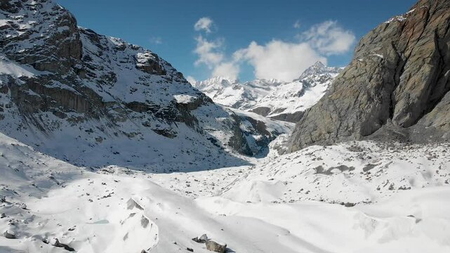 Aerial view of Gorner glacier in Zermatt, Switzerland covered in snow on a sunny winter day in the Swiss Alps with a view of Ober Gabelhorn and glacial morraines.