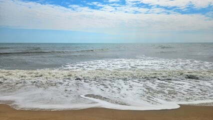 The ocean wave on high tide day in rain season with cloudy sky beach landscape.