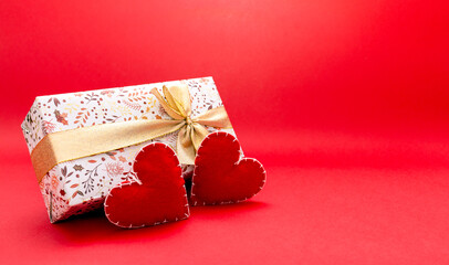 love and relationship abstraction, handmade wool red hearts next to wrapped gift, dating and valentine's day concept