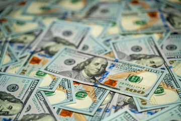 Variety of hundred dollar bills scattered on a flat surface