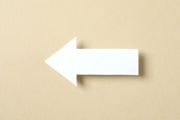 Paper arrow on color background, top view