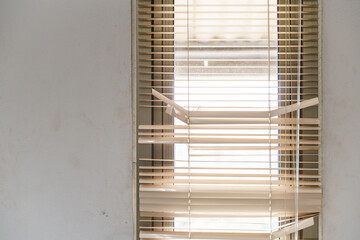 Close-ups of window blinds with a pull cord and partially broken blinds creating interesting light and shadow patterns.