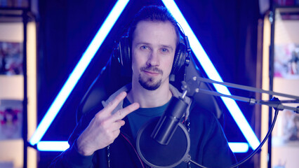Male gaming streamer greet audience with piece sign