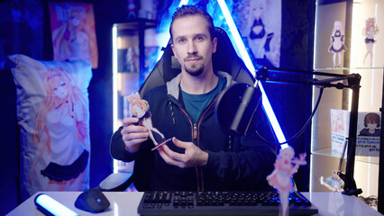 Anituber influencer reviewing anime girl figurine from in merchandise room.