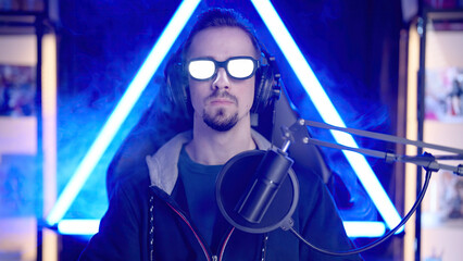 Male gaming streaming with the glowing glasses like a villain