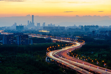 Road towards the sun: night view of Beijing CBD skyline at sunset