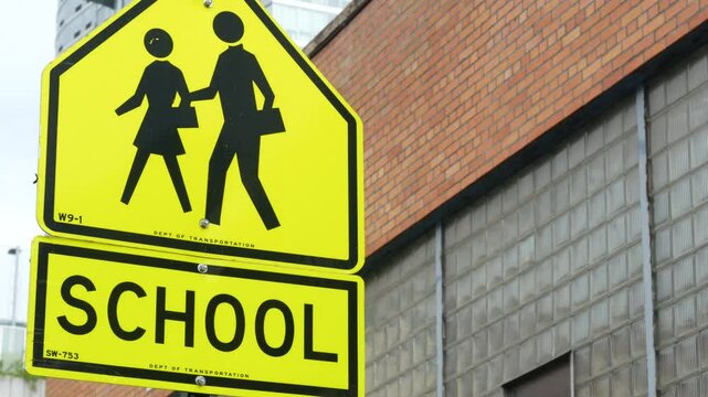 School zone yellow road sign, pedestrian crossing. Children safety on street, New York City. Transport and education symbol, USA . Traffic roadsign in Queens, Long Island, Hunters point.