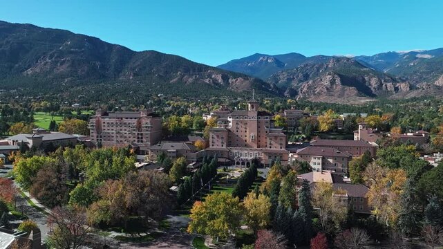 Aerial drone establishing pullback of Colorado Springs showcasing The Broadmoor and surrounding fall foliage