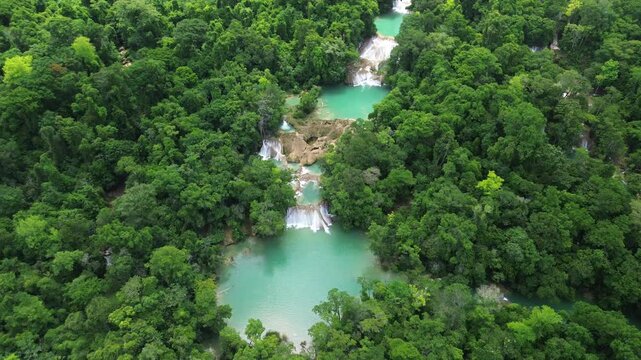 Aerial establishing of Cascadas Roberto Barrios waterfalls surrounded by lush tropical forest, turquoise green pools