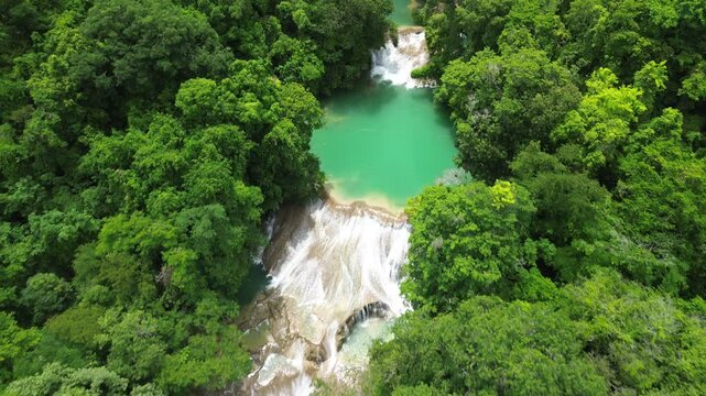 Aerial pullback of Roberto Barrios waterfalls cascading into turquoise pools within the forest smooth water, no people