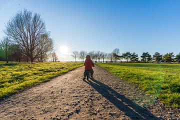 A young boy driving his bike at the Cospudener Lake in Leipzig in late autumn