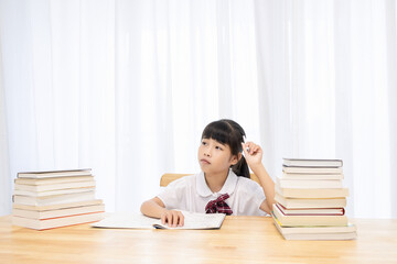 The little Chinese girl is doing homework at home