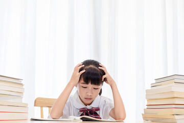 The little Chinese girl is doing homework at home