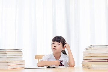 The little Chinese girl is doing homework at home