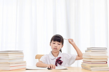 The little Chinese girl is doing homework at home