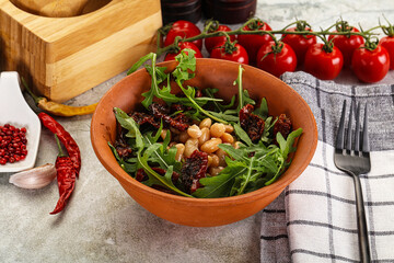 White canned beans with arugula and dry tomatoes