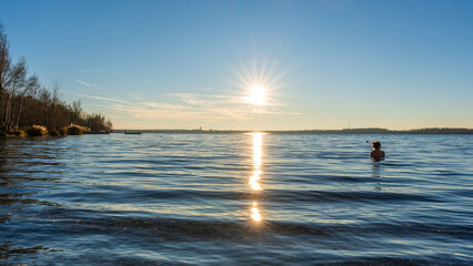 Eine Frau beim Winterbaden in einem See im Spätherbst