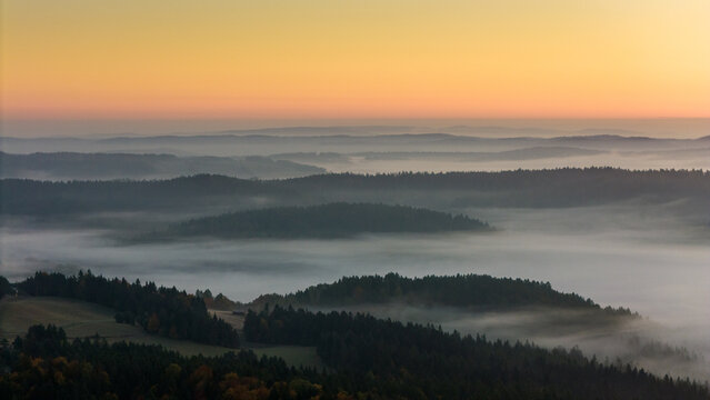 Aerial drone view of sunrise above clouds in mountains