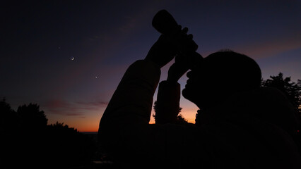 Amateur astronomer looking at the evening skies, observing planets, stars, Moon and other celestial...